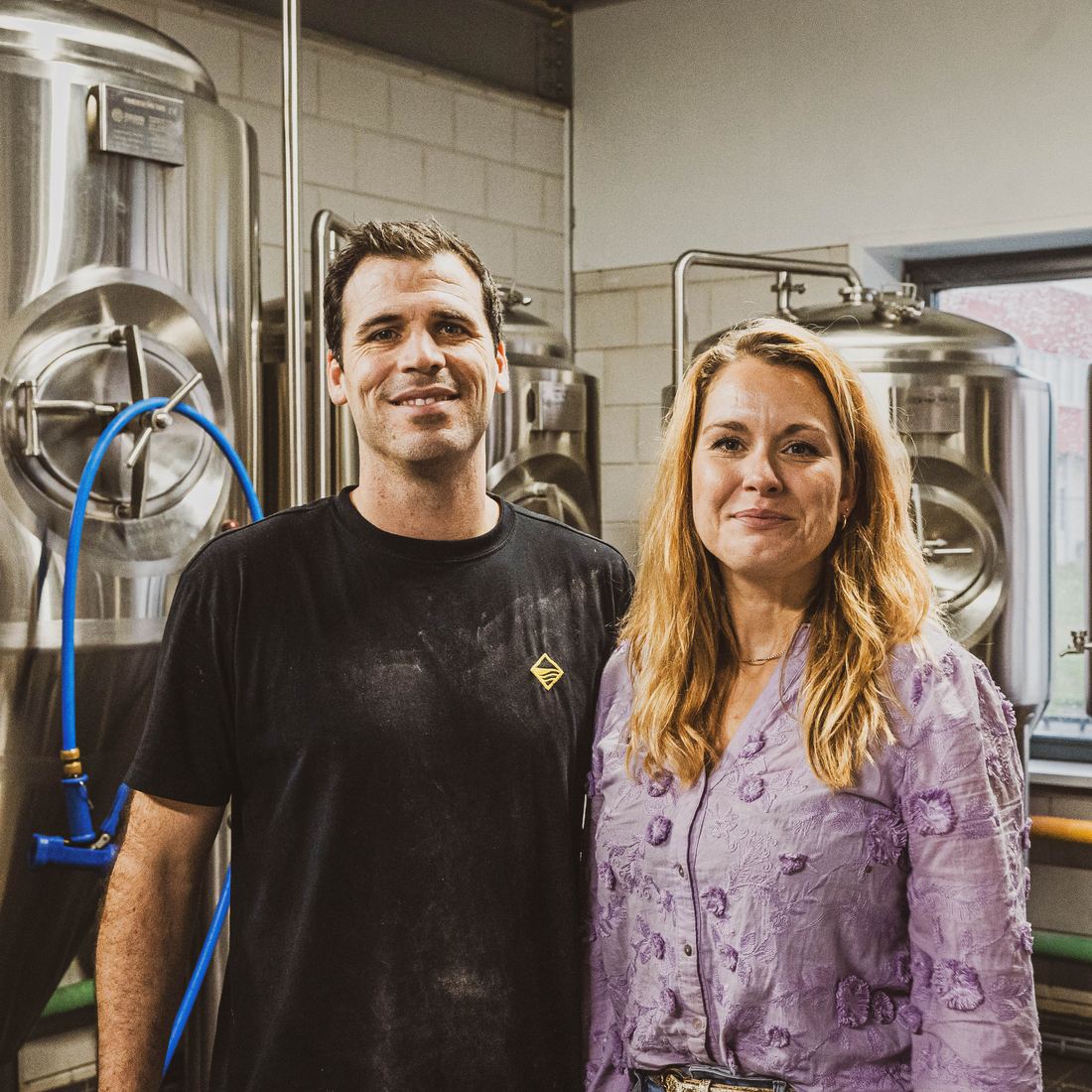 Loes en Martijn de Jong naast de brouwketels van Brouwerij De Toekomst