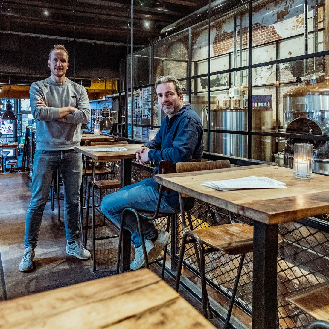 Sander Arkenbout en Thijs van de Donk op de bovenverdieping van het Delfts Brouwhuis, met de brouwketels achter glas